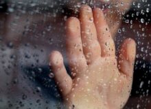 Rainy Window Pane with Kid's Hand