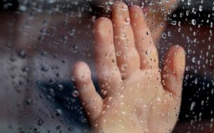 Rainy Window Pane with Kid's Hand